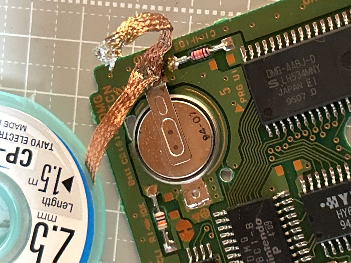 はんだ吸い取り線が電池のタブ部分にくっついてしまっている様子