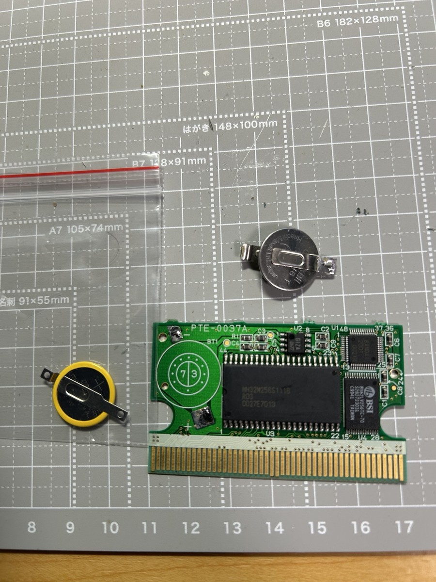 古いボタン電池を取り外した基板と交換用の新しいタブ付きCR1616